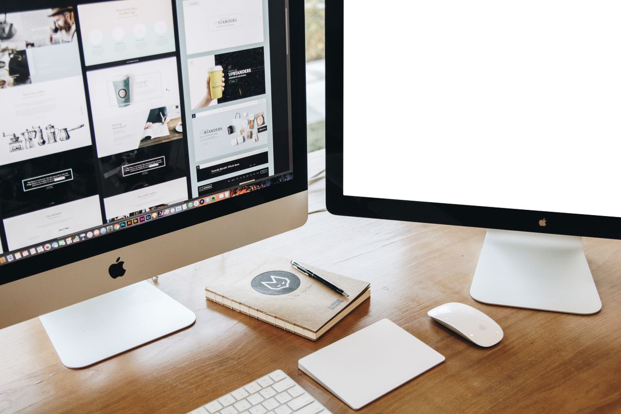 creative Vue en plongée d’un bureau élégant équipé de deux écrans, d’un clavier, d’une souris et d’accessoires modernes.